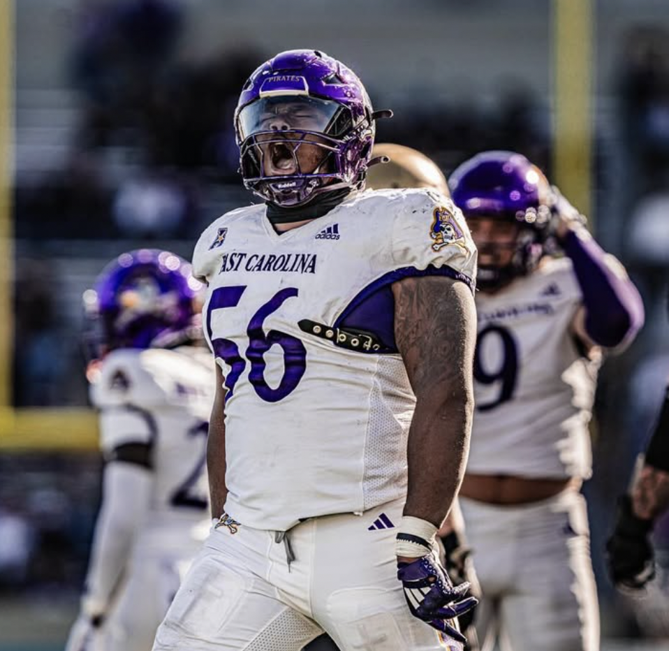Football players in white uniforms preparing on the field.
